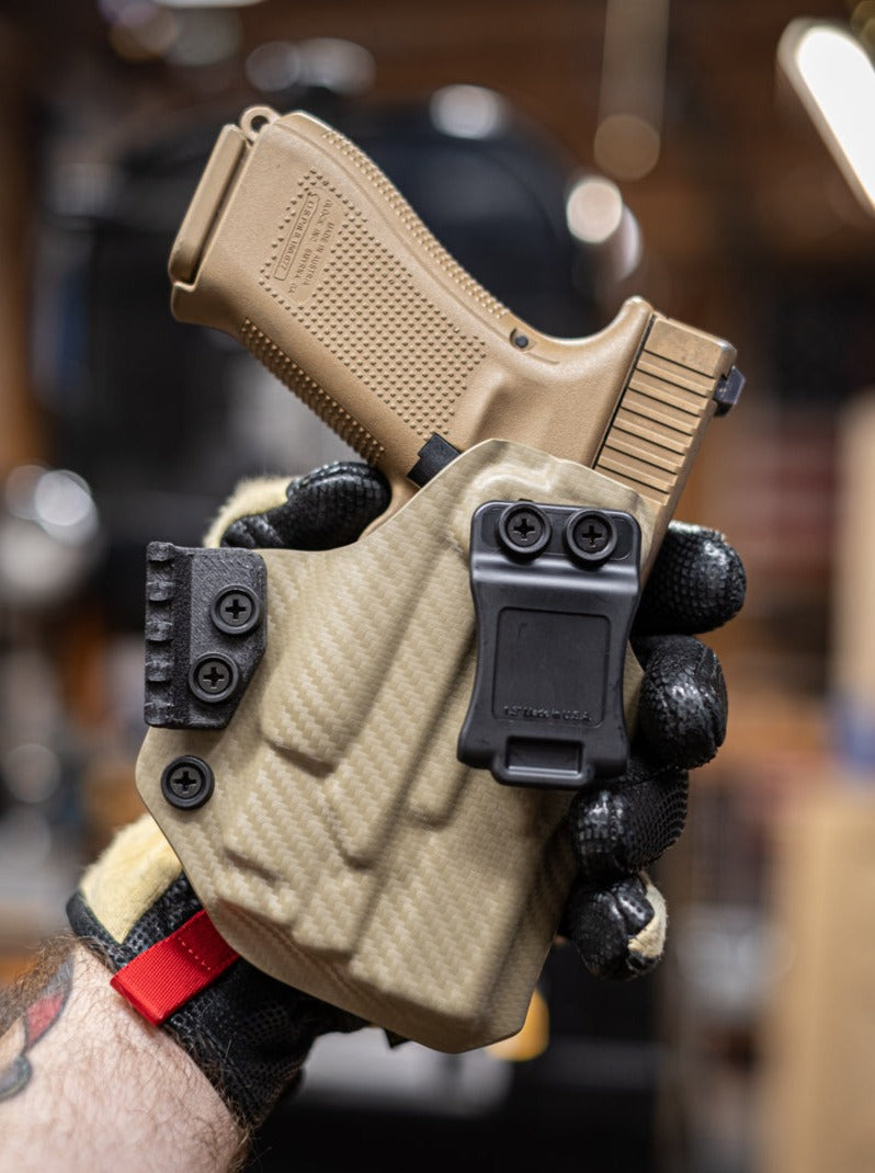 Inside the Waistband Kydex Holster in FDE Carbon Fiber. Shown here for a Glock 19 with Olight Baldr Mini light.