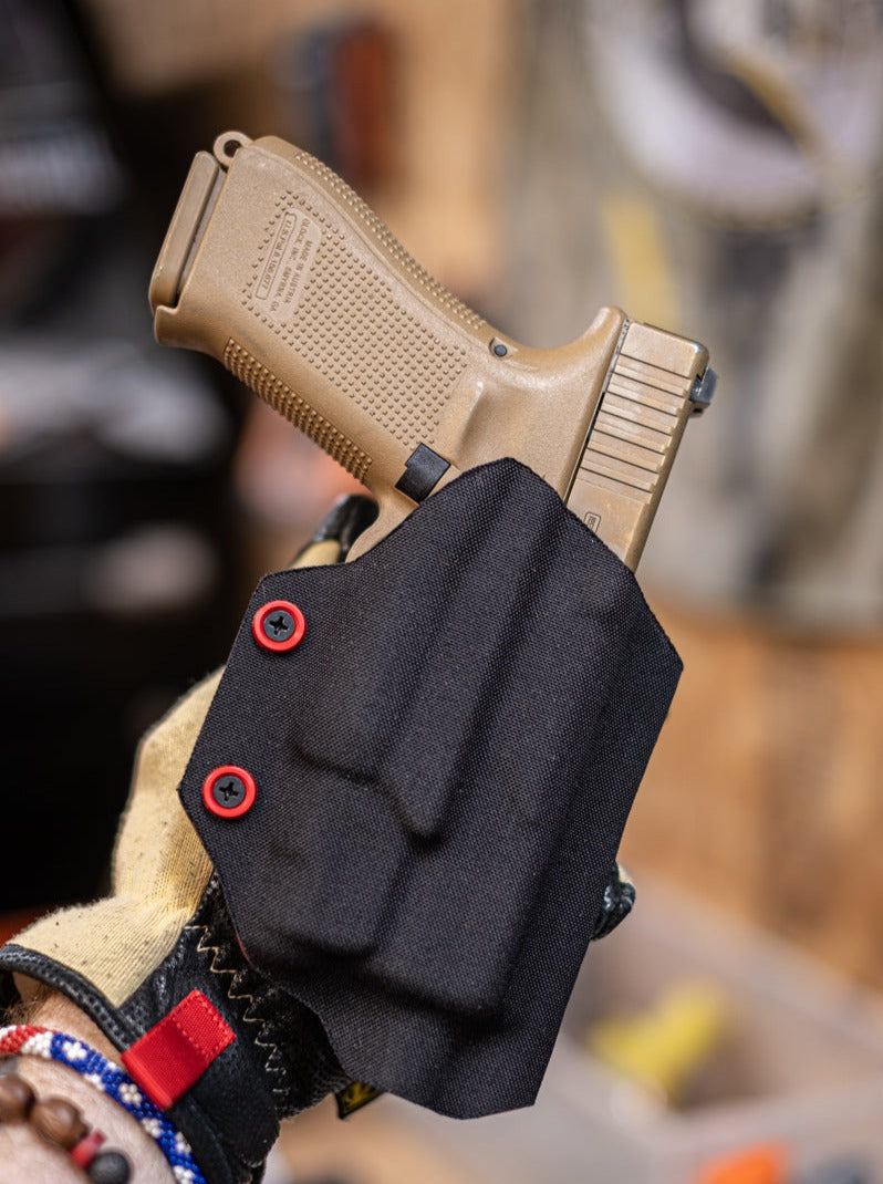 Fold-Over Outside the Waistband Kydex Holster wrapped in Black Cordura Fabric. Shown here for a Glock 19 with an Olight Baldr Mini.