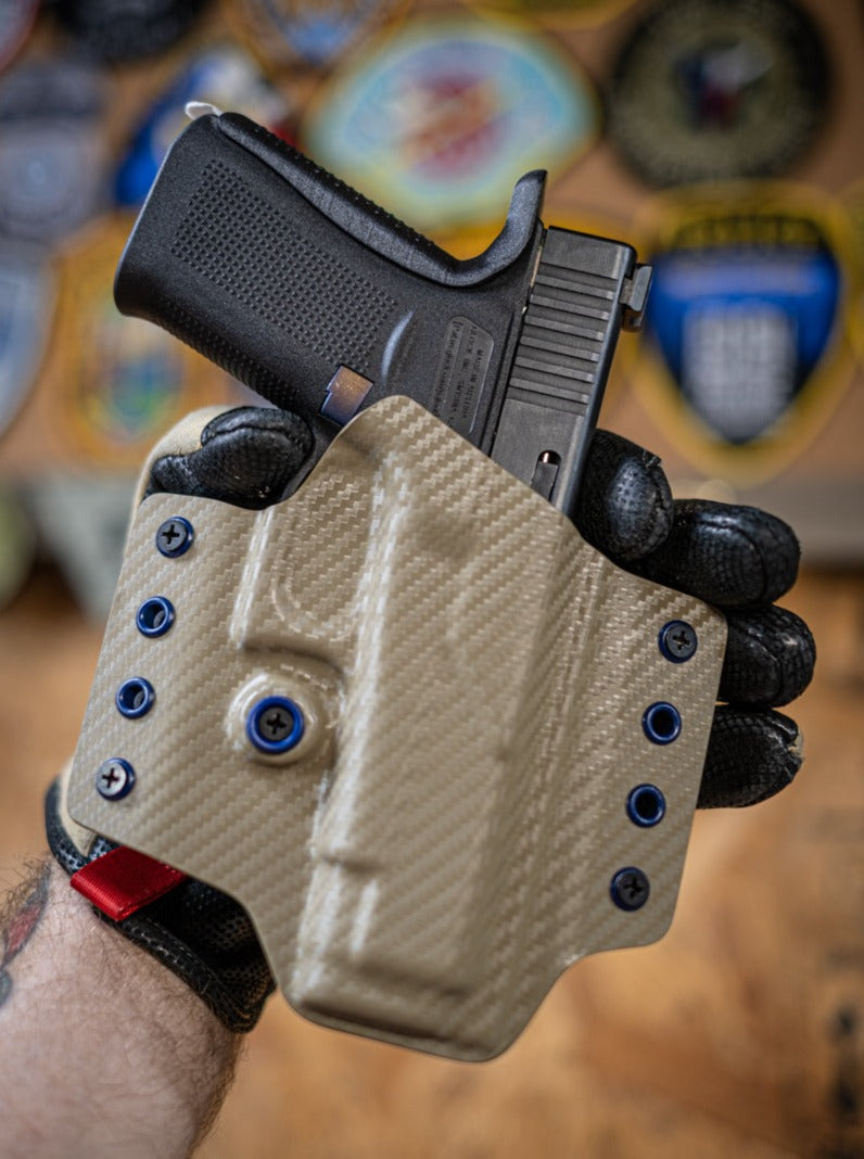 Outside the Waistband Kydex Holster in FDE Carbon Fiber. Shown here is a holster for a Glock 48.
