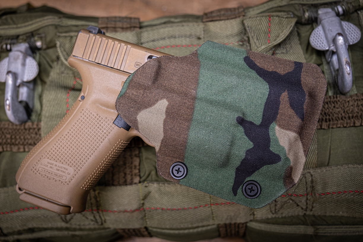 Fold-Over Outside the Waistband Kydex Holster for a Glock 19 with and Inforce APL-C light. Wrapped up in Woodland Camo.