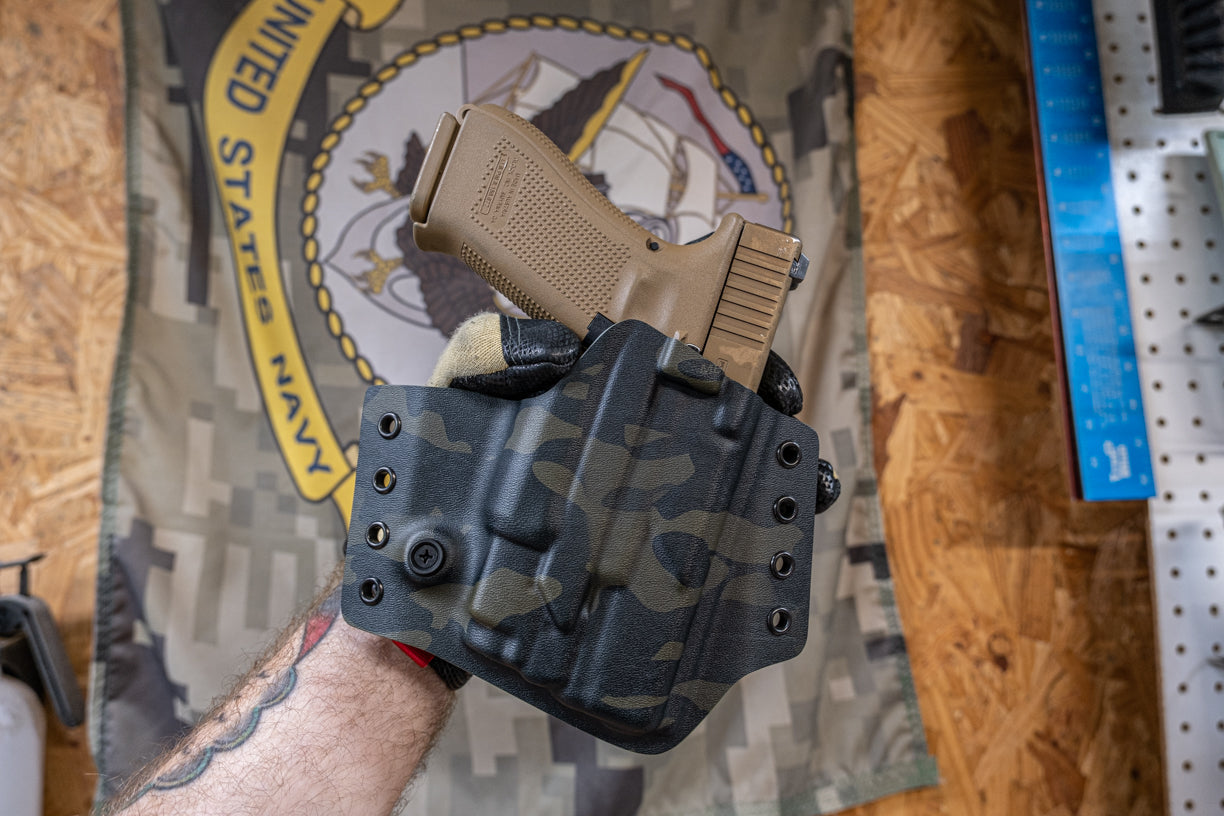 Outside the Waistband Kydex holster for a Glock 19 with Olight Baldr Mini. Shown here in Multicam Black.