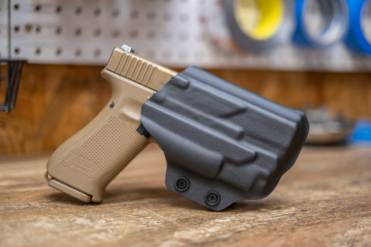 Fold-over Outside the Waistband Kydex holster in black kydex for a Glock 19 with an Olight Baldr Mini.