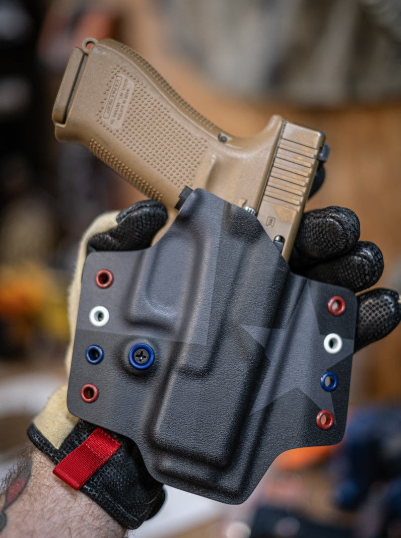 Outside the Waistband Kydex holster non-light bearing with our Black on Black Texas Flag with Red White and Blue eyelets.