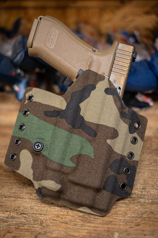Outside the Waistband Light Bearing Kydex Holster for a Glock 19 or Glock 17 with TLR-1 light.  Covered in Woodland Camo fabric.